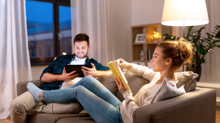 Par sidder i sofa med standerlampe bagved