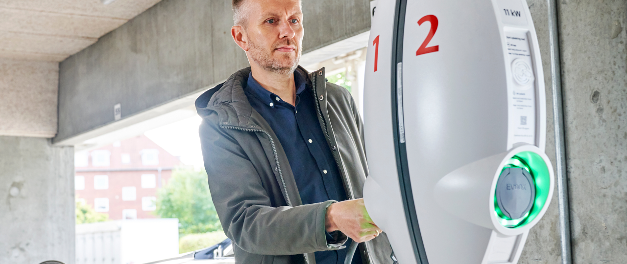 Mand lader sin elbil ved en boligforening