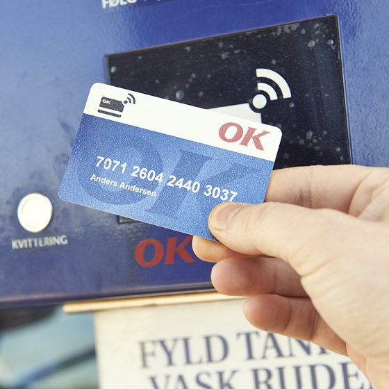 Hånd med et OK Truck Diesel-kort med kontaktfri betalingsmulighed