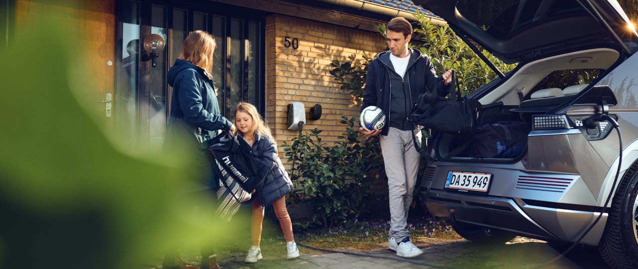 Familie i færd med at pakke bil der er ved at blive ladet op