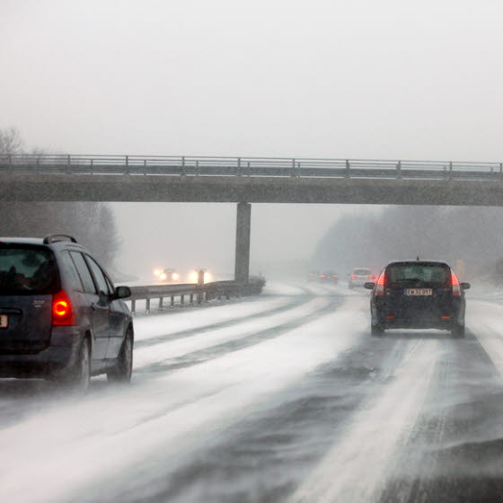 Biler på motorvej med sne og fygning