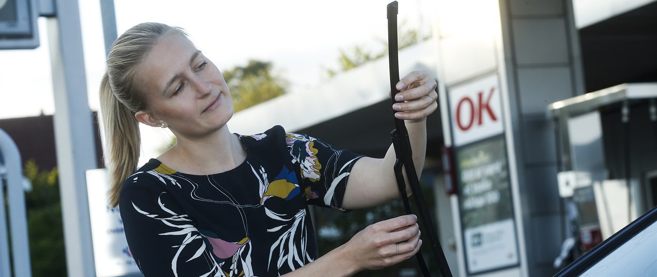 Kvinde ved OK-tankstation ordner vinduesvisker
