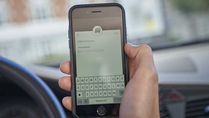 Mobiltelefon med visning af tilføj køretøj til OK's app 