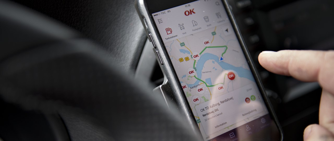 Mobiltelefon i førerkabine på bil med kortvisning af OK's app