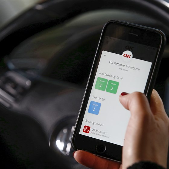 Mobiltelefon med OK's app med valg af tankstander på skærmen