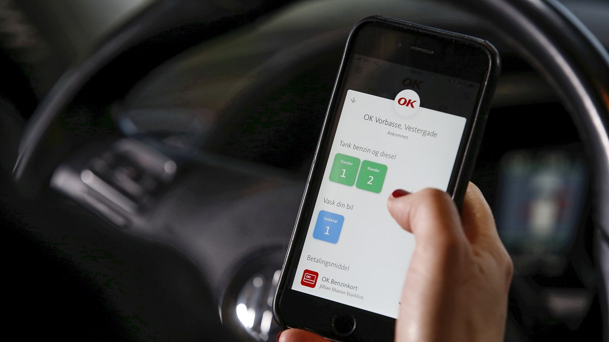 Mobiltelefon med OK's app med valg af tankstander på skærmen
