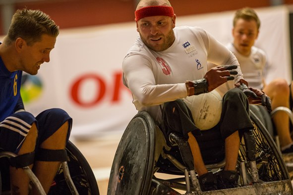 Tre mænd i kørestole dyrker sport