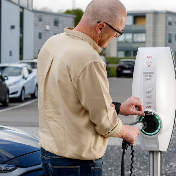 Mand lader sin bil ved ladestander