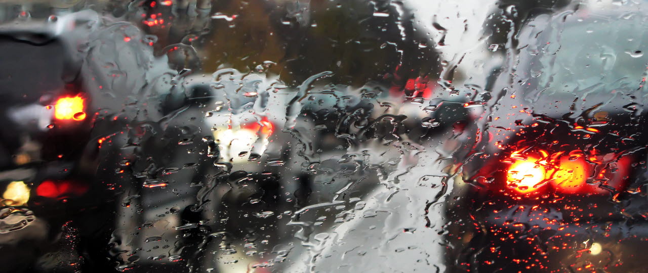 Tæt trafik set fra regnvåd bilrude
