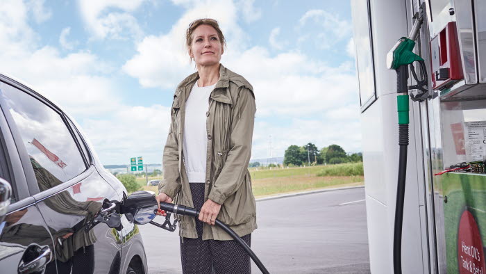 Kvinde i færd med at tanke bilen hos OK