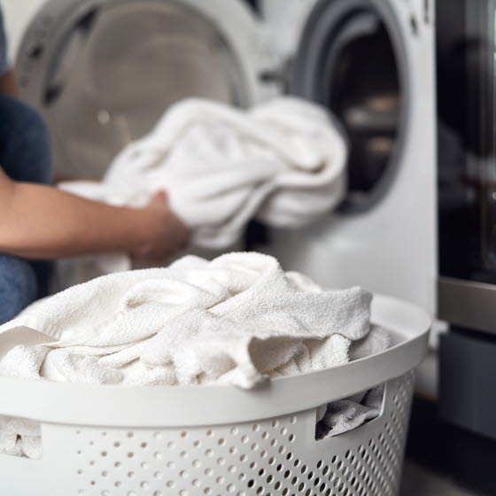 Kurv med håndklæder foran vaskemaskine