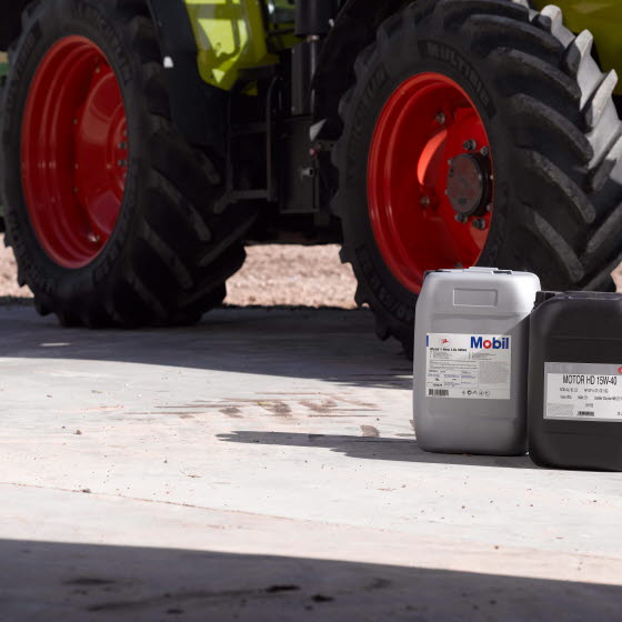 To dunke med smøremidler til landbruget ved siden af traktor