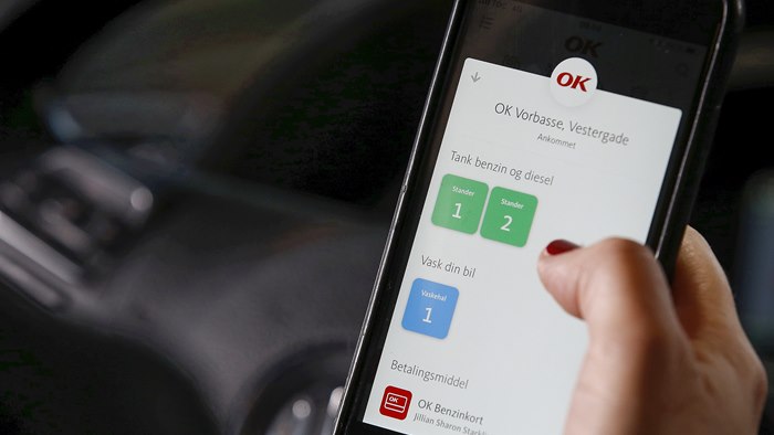 Mobiltelefon med OK's app med valg af tankstander på skærmen
