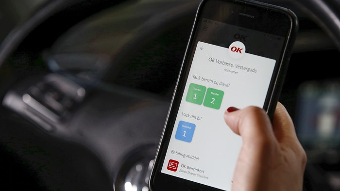 Mobiltelefon med OK's app med valg af tankstander på skærmen