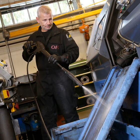 Mand servicerer maskine smøremidler
