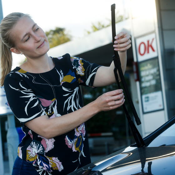 Kvinde ved OK-tankstation ordner vinduesvisker