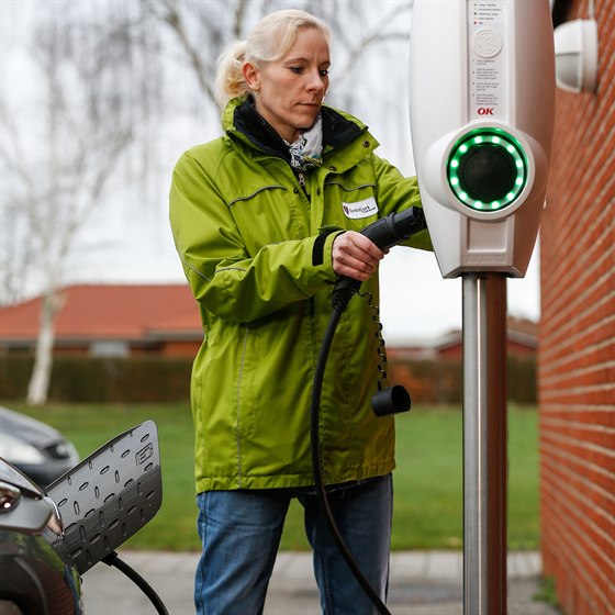 Medarbejder fra Syddjurs Kommune ved ladestander fra OK med ladestik