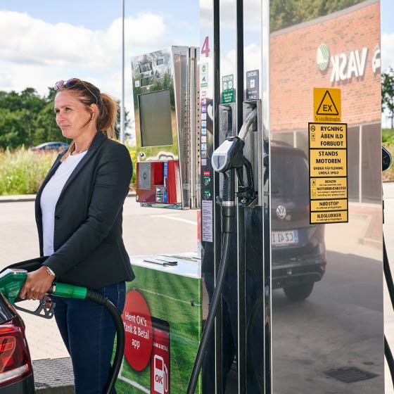Kvinde tanker sin bil på en OK Station