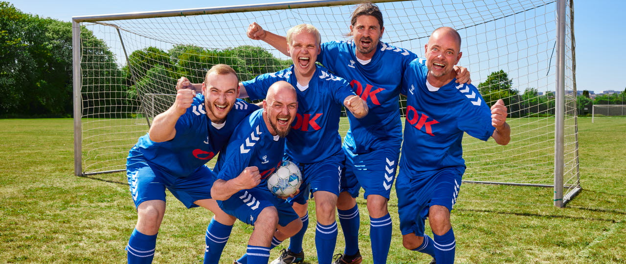 Oldboys-fodboldhold på fodboldbane foran mål