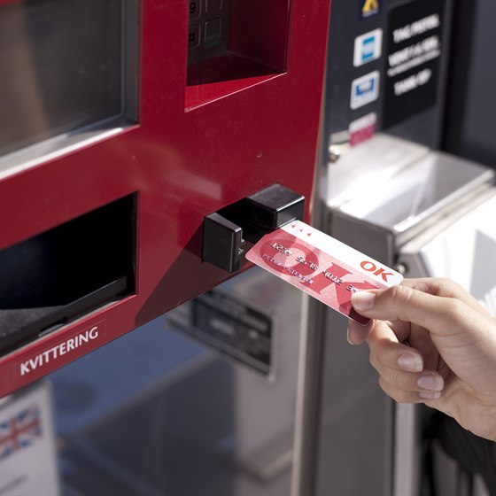 Hånd med OK Kort ved automat på tankstation