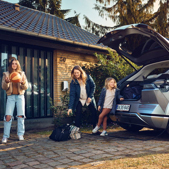 Familie ved elbil med hjemmelader