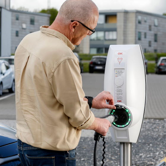 Mand lader sin bil ved ladestander