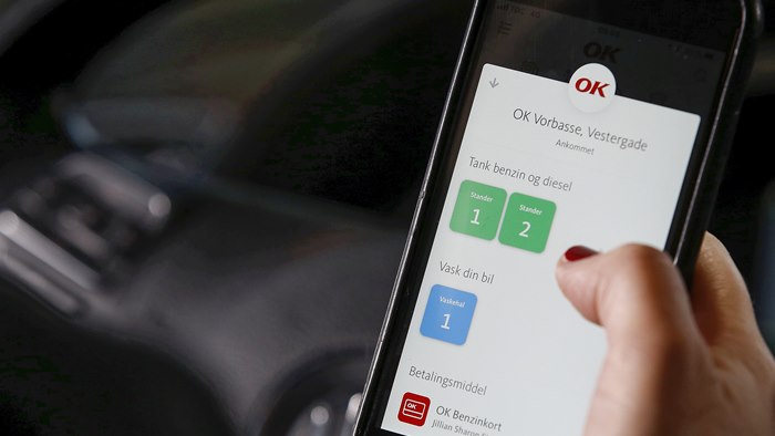 Mobiltelefon med OK's app med valg af tankstander på skærmen