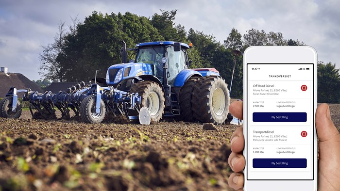 Visning af OK's bestil-app på mobiltelefon med traktor på mark i baggrunden