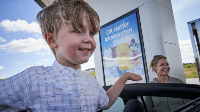 Dreng står og kigger ud af bilens soltag