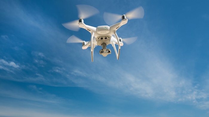 Flyvende drone på blå himmel