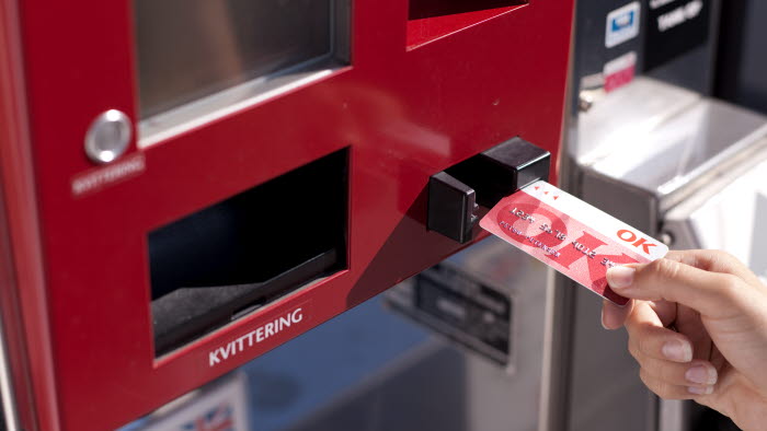 Hånd med OK Kort ved automat på tankstation