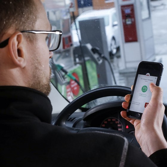 Mand i bil i færd med at bruge OK's app til at betale tankning