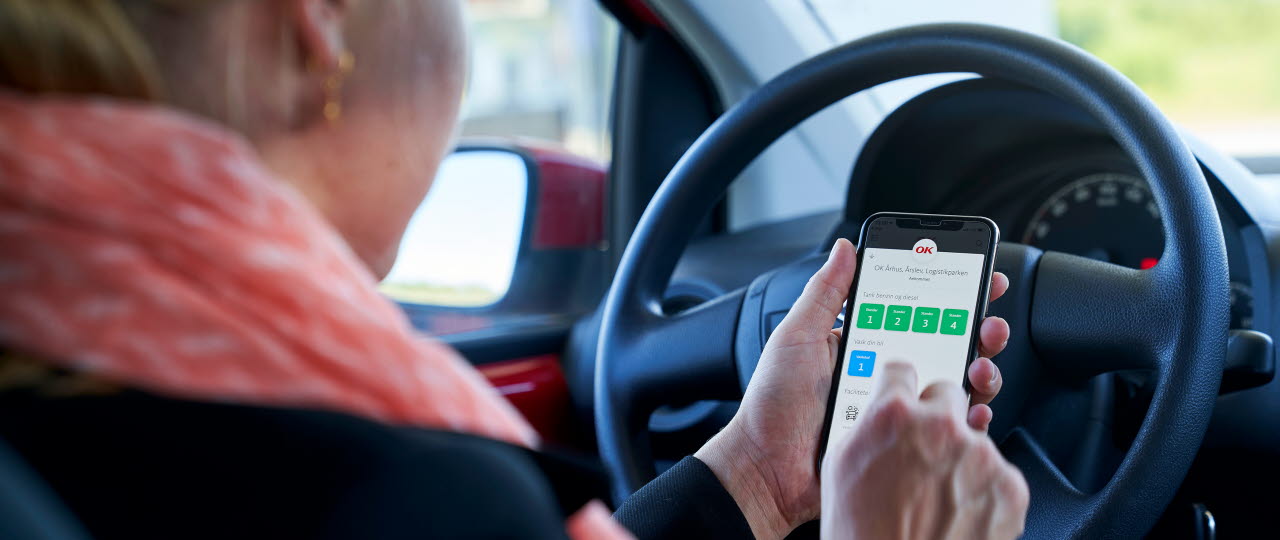 Kvinde bruger OK-appen i bil
