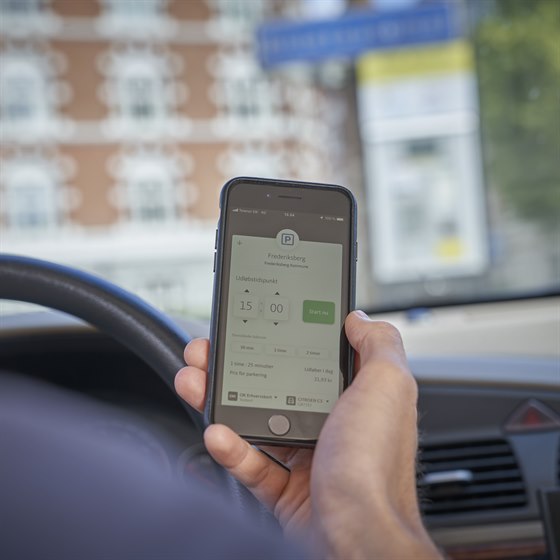 Mobiltelefonskærm med visning af hvordan du indstiller betaling med OK-appen for parkering