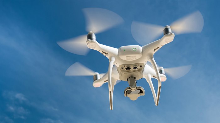 Flyvende drone på blå himmel