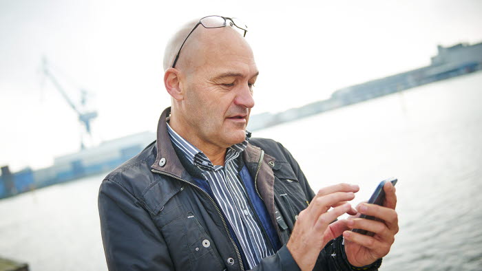 Mand med mobiltelefon i hånden