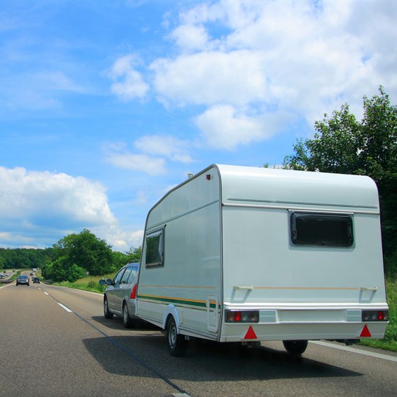 Bil med campingvogn på landevej