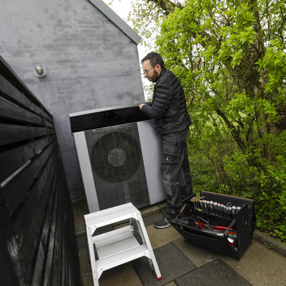 Mand installerer Vølund varmepumpe udenfor