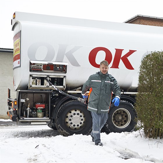 En af OK's tankvognschauffører på vej ind til hus med olieslange i hånden