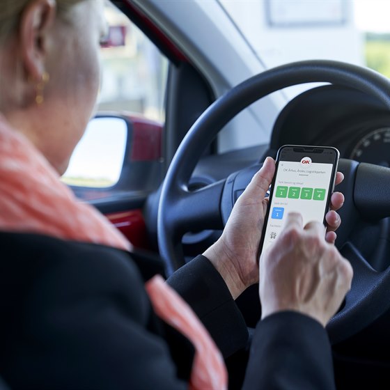 Kvinde bruger OK-appen i bil