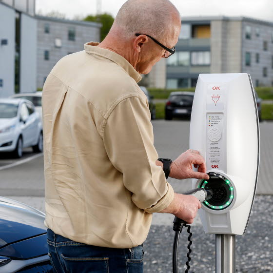 Mand lader sin bil ved ladestander