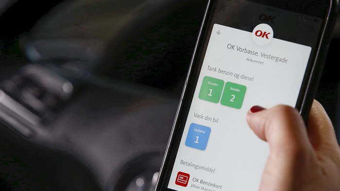 Mobiltelefon med OK's app med valg af tankstander på skærmen