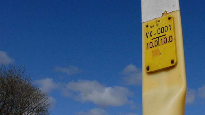 Naturgasmarkør i landskab med blå himmel