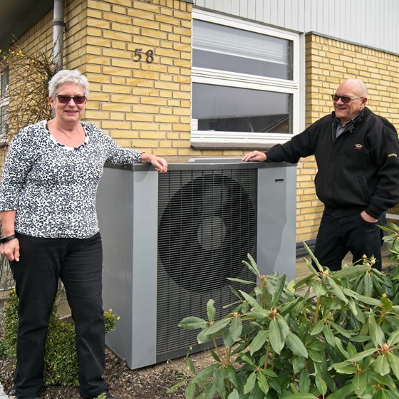 Mand og dame står sammen ved deres varmepumpe