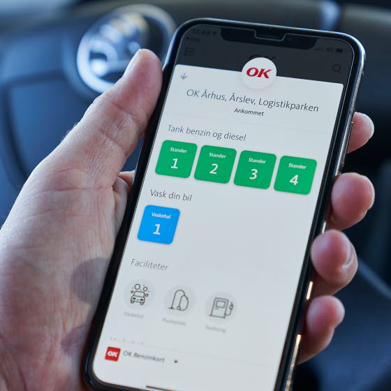 Hånd holder mobil med OK's app