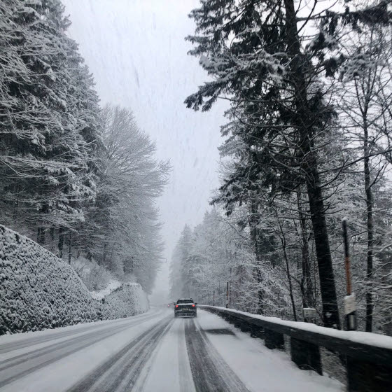 Bil kører på bjerg med sne
