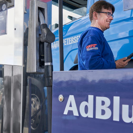 Mand med mobil i hånden ved siden af lastbil