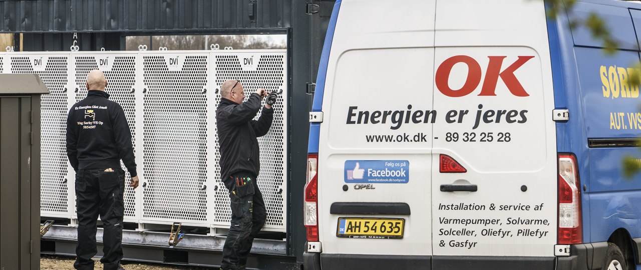 To mænd i færd med at installere stor varmepumpeløsning til erhverv