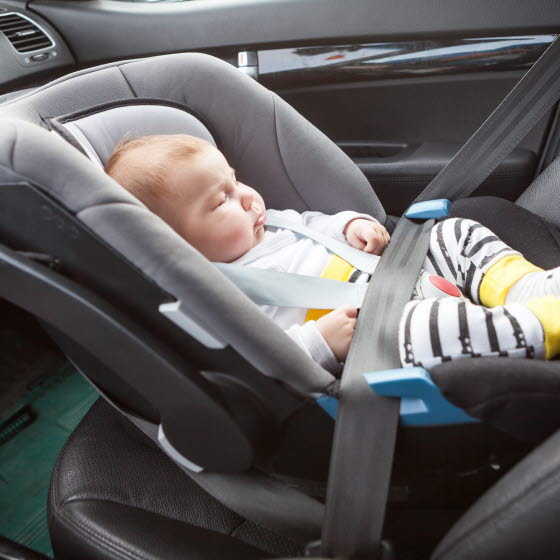 Baby sidder i autostol i en bil