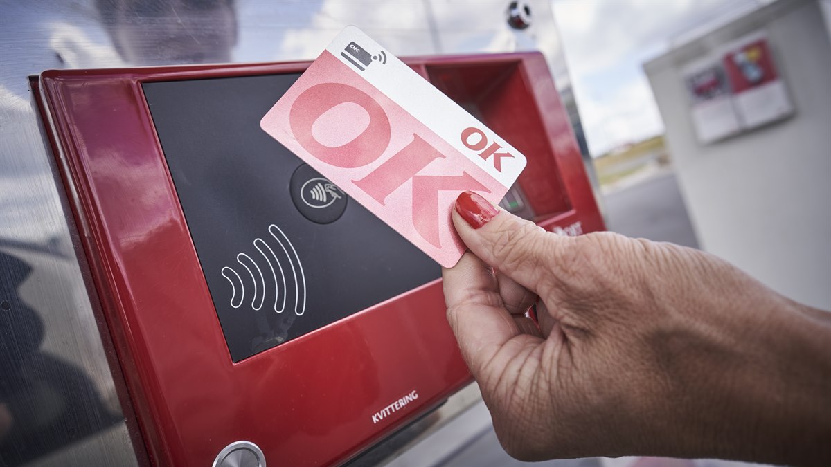 Kvindehånd der holder et OK Kort op til kontaktløs betaling